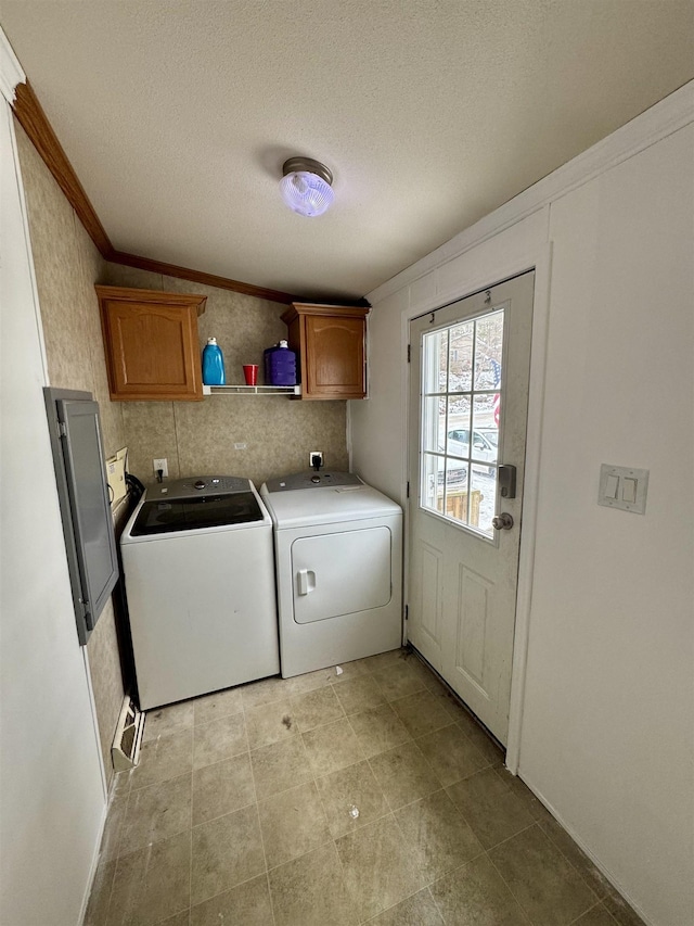 laundry room with cabinets, crown molding, a textured ceiling, and washer and clothes dryer