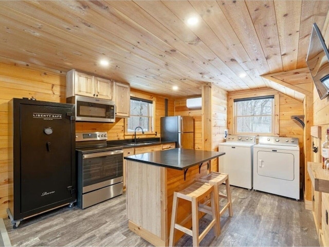 kitchen featuring sink, appliances with stainless steel finishes, a center island, separate washer and dryer, and wooden ceiling