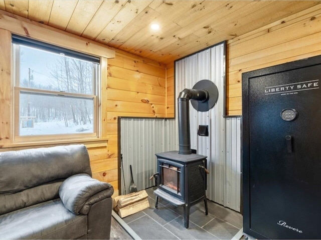 sitting room featuring a wood stove, wood ceiling, and wooden walls