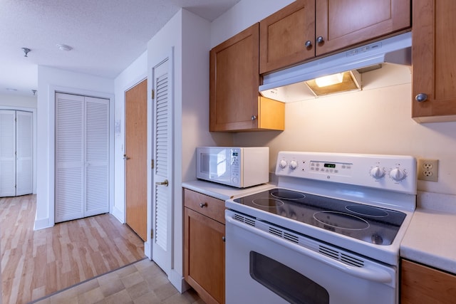 kitchen featuring white appliances and a textured ceiling