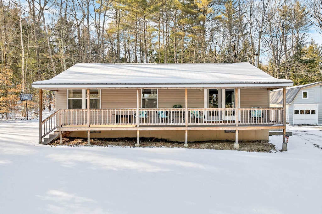 view of front of house featuring an outbuilding, a garage, and covered porch