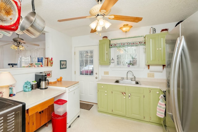 kitchen with ceiling fan, sink, a textured ceiling, and stainless steel refrigerator