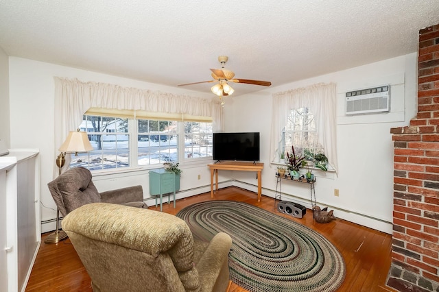 living room with a wealth of natural light, a wall unit AC, wood-type flooring, and baseboard heating