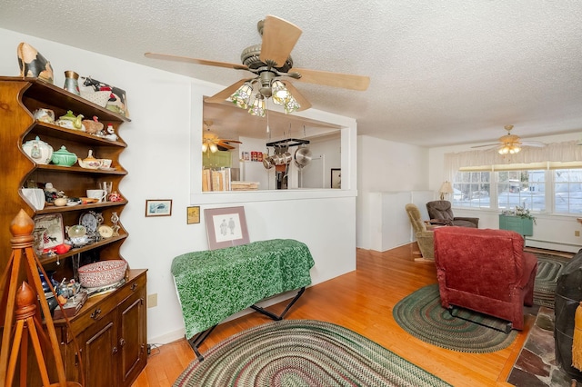 interior space with a baseboard radiator, a textured ceiling, and light hardwood / wood-style floors