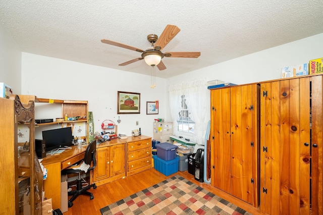 office area featuring ceiling fan, a textured ceiling, and light wood-type flooring