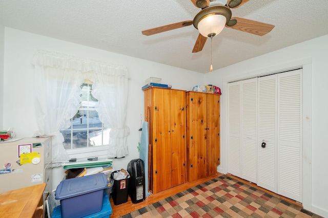 bedroom featuring ceiling fan, a closet, and a textured ceiling