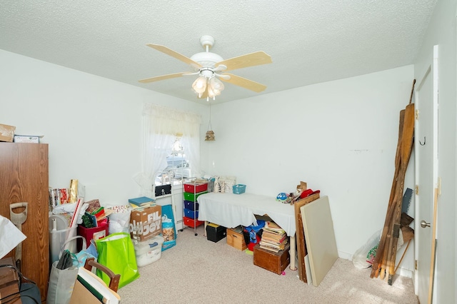 carpeted bedroom featuring a textured ceiling and ceiling fan