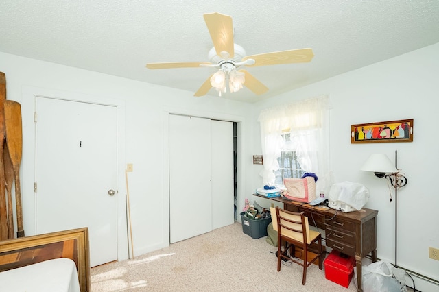 home office with light carpet, a textured ceiling, and ceiling fan