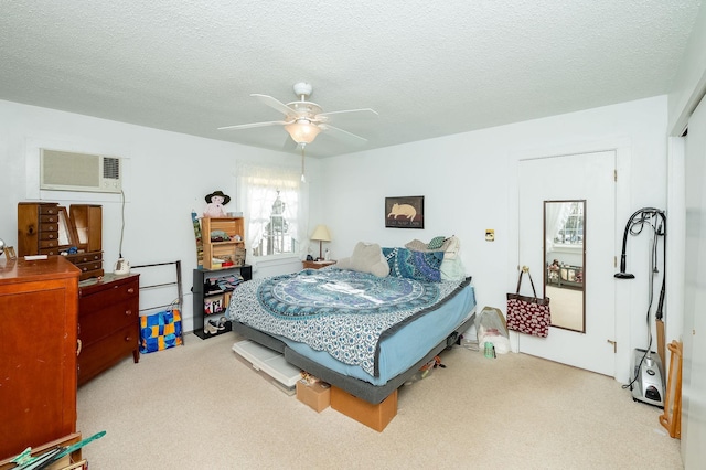 bedroom featuring ceiling fan, a wall mounted AC, and a textured ceiling