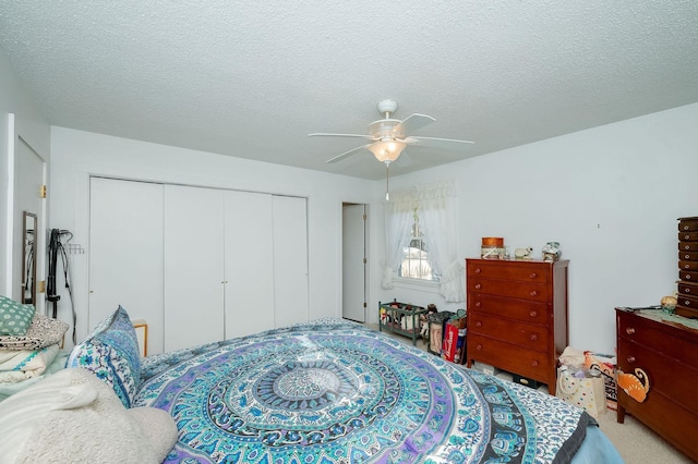 bedroom with a textured ceiling, a closet, and ceiling fan