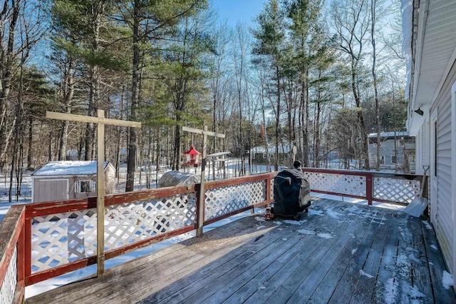 snow covered deck with a storage shed