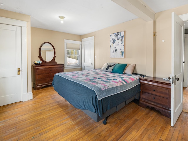 bedroom featuring beam ceiling and hardwood / wood-style floors