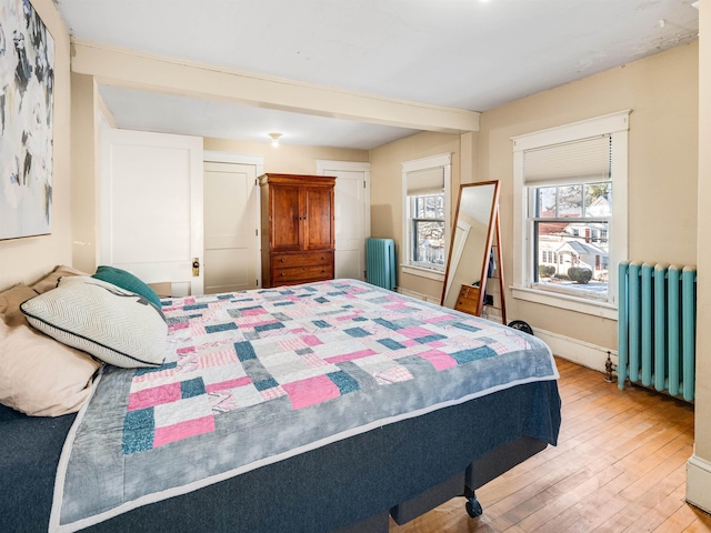 bedroom with radiator and light hardwood / wood-style flooring