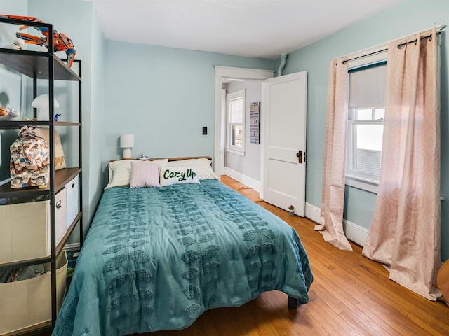 bedroom with multiple windows and hardwood / wood-style floors