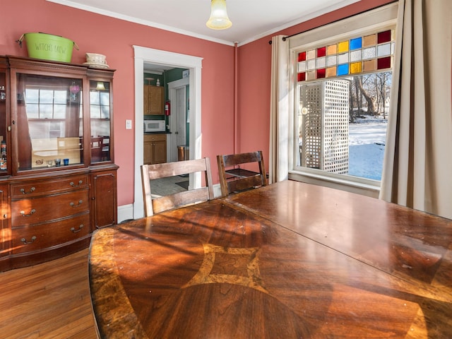 dining area with hardwood / wood-style floors and ornamental molding