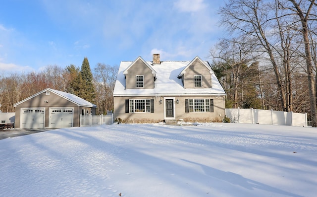 cape cod house featuring a garage and an outbuilding