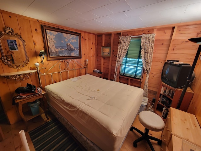 bedroom featuring wooden walls