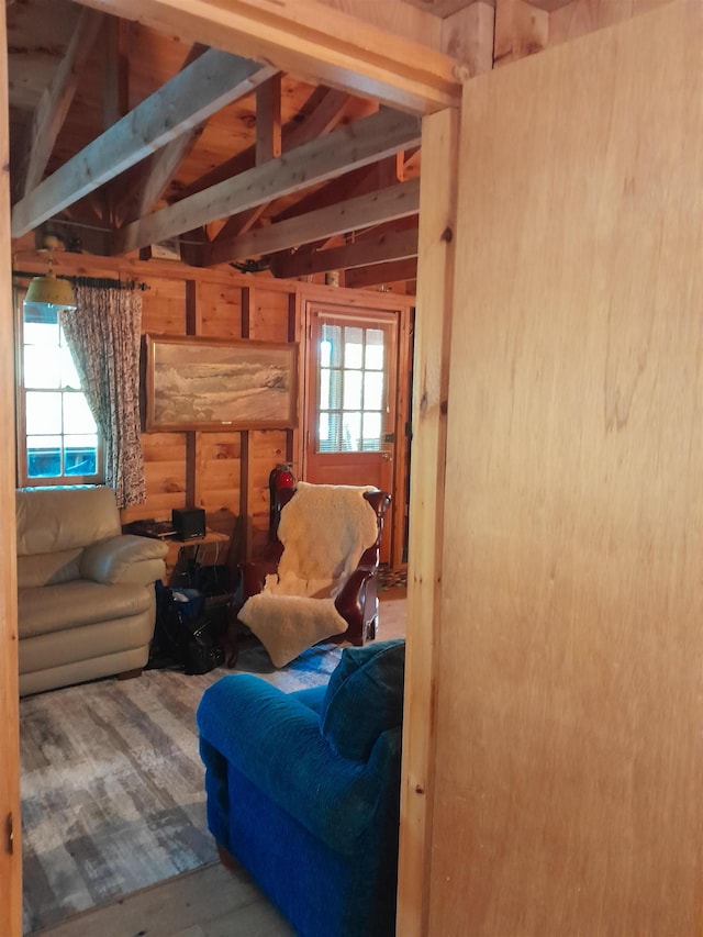 living room with vaulted ceiling, a healthy amount of sunlight, and wood walls