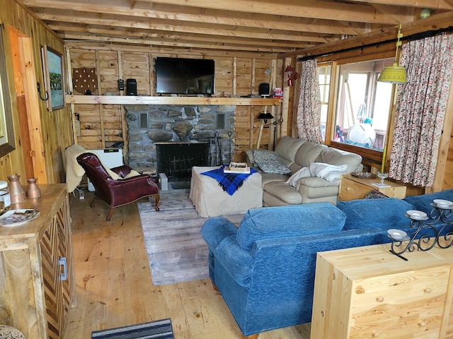 419 Belleau Blvd, Wakefield, NH 03830 - living area featuring hardwood / wood-style flooring, beam ceiling, wooden walls, and a stone fireplace