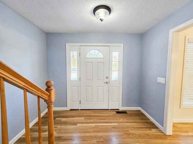 entrance foyer featuring a textured ceiling and light hardwood / wood-style flooring