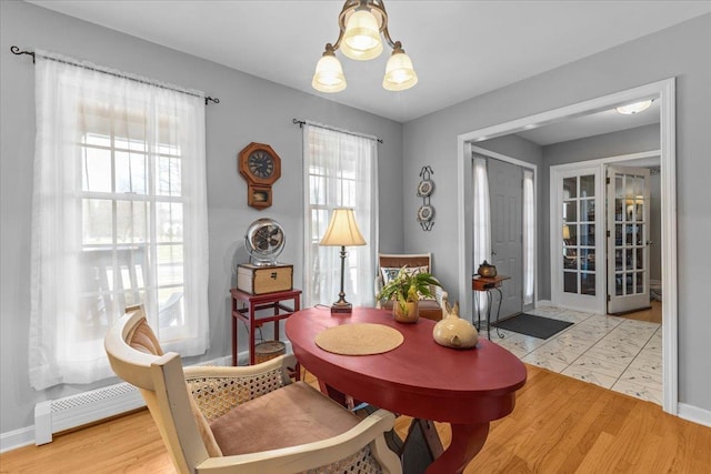 sitting room featuring an inviting chandelier, light wood-type flooring, and baseboard heating