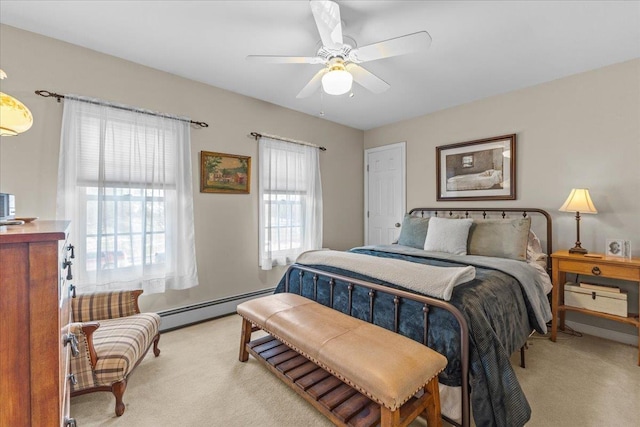 carpeted bedroom with multiple windows, a baseboard heating unit, and ceiling fan