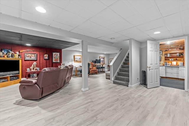 living room featuring a paneled ceiling and light wood-type flooring