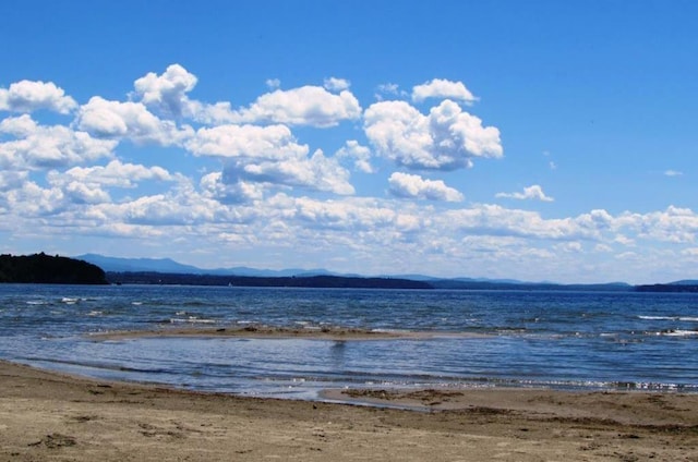 view of water feature with a mountain view and a view of the beach