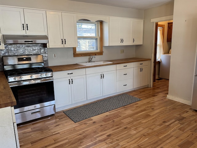 kitchen with sink, light hardwood / wood-style flooring, wooden counters, stainless steel gas range oven, and white cabinets