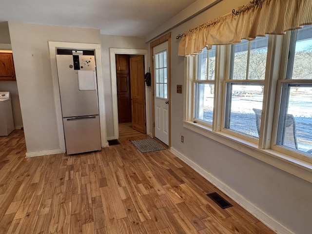 doorway featuring washer / dryer and light hardwood / wood-style floors