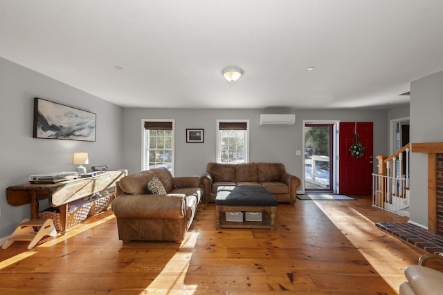 living room with light hardwood / wood-style flooring and a wall mounted AC