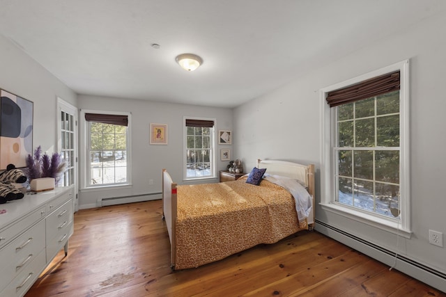 bedroom with wood-type flooring and baseboard heating