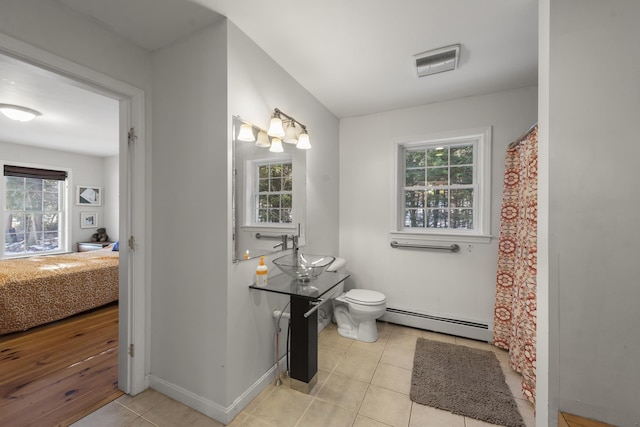 bathroom featuring a wealth of natural light, tile patterned floors, and baseboard heating