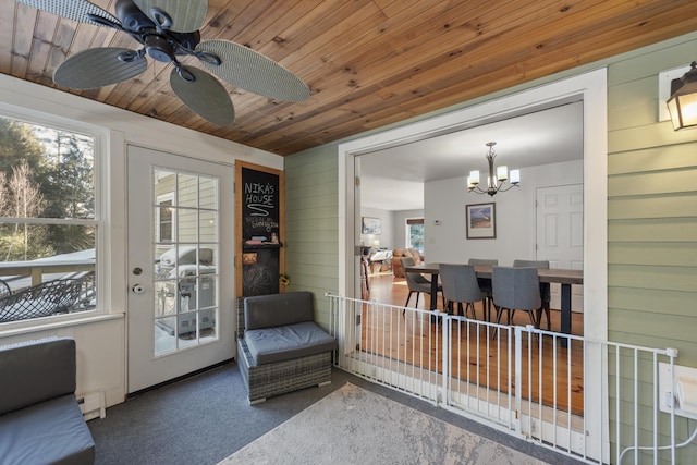 interior space with wooden walls, a wealth of natural light, carpet floors, and wooden ceiling