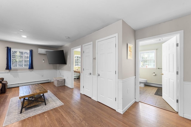 unfurnished living room featuring a baseboard heating unit and light hardwood / wood-style floors