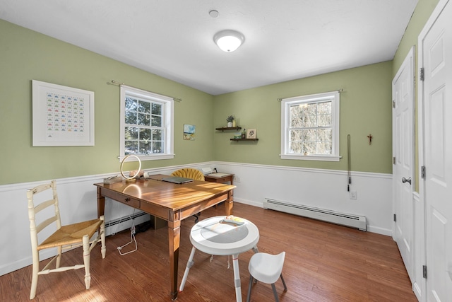 interior space featuring hardwood / wood-style flooring, a baseboard radiator, and a healthy amount of sunlight