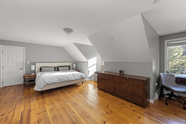 bedroom with vaulted ceiling and light wood-type flooring