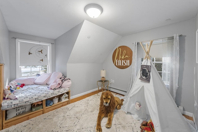 bedroom featuring hardwood / wood-style flooring, a baseboard radiator, and lofted ceiling