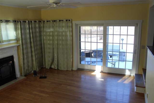 unfurnished living room featuring crown molding, hardwood / wood-style flooring, and ceiling fan