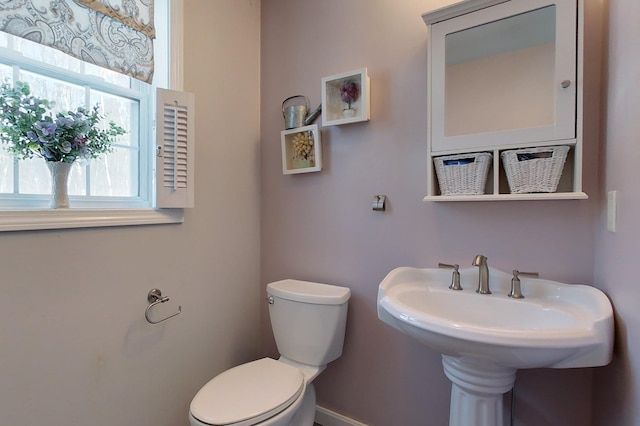 bathroom with sink, a wealth of natural light, and toilet