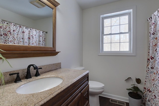 bathroom with vanity, toilet, hardwood / wood-style floors, and a wealth of natural light