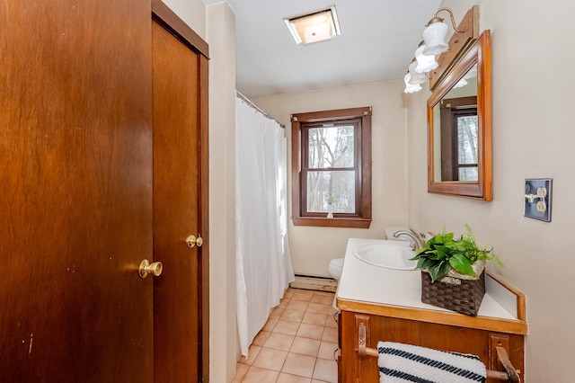 bathroom with tile patterned flooring, vanity, baseboard heating, and toilet