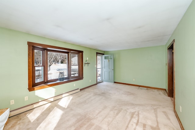 empty room featuring light colored carpet and baseboard heating