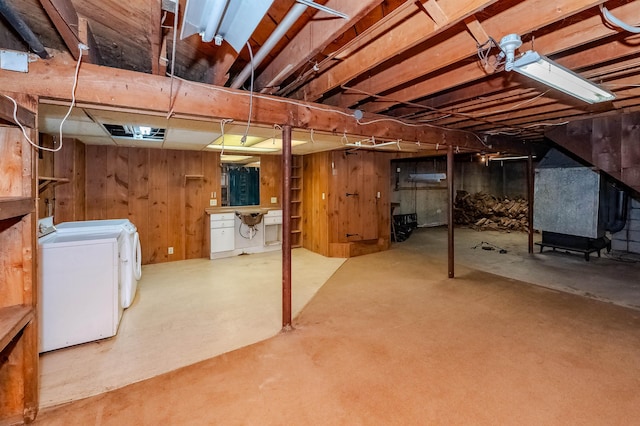 basement featuring washer and dryer and wood walls