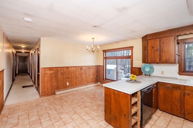 kitchen with a baseboard radiator, black dishwasher, hanging light fixtures, and a wealth of natural light