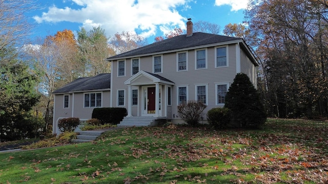 colonial-style house featuring a front lawn