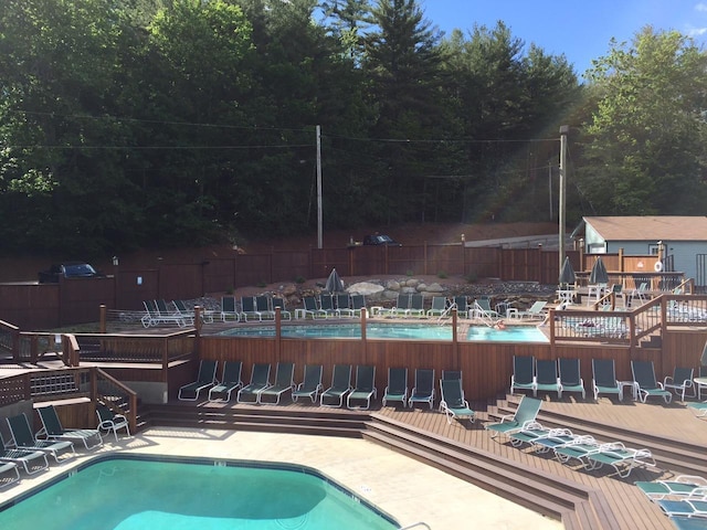 view of swimming pool with a wooden deck and a patio area