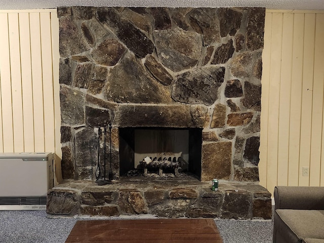 details featuring a stone fireplace, carpet, and wood walls