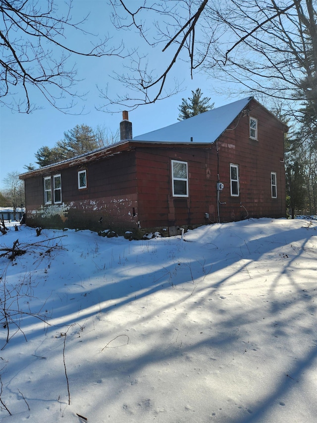 view of snow covered back of property