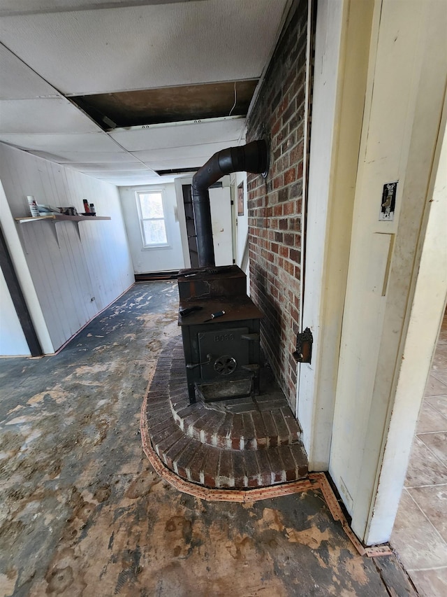 interior details featuring a drop ceiling and a wood stove